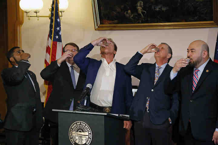 Arnold Schwarzenegger takes a shot of  Austrian schnapps with Gov. John Kasich and legislative leaders to celebrate passing a congressional redistricting measure during a press conference in the State Room at the Statehouse in Columbus. The former Republican California governor has advocated for reforms that end gerrymandering of political districts.     (Kyle Robertson / The Columbus Dispatch)
